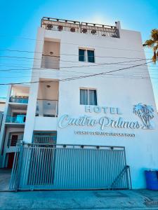 a hotel with a sign on the side of a building at Cuatro Palmas Hotel in Puerto Peñasco