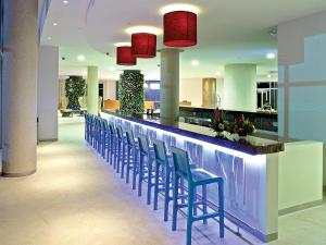 a bar with blue chairs and red lights at Las Americas Torre Del Mar in Cartagena de Indias