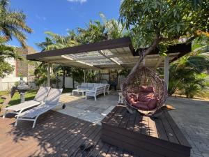 a hammock hanging from a tree on a patio at Lakaz Mapou - Magnifiques Appartements rénovés de 3 chambres et 2 salles de bains in Rivière Noire