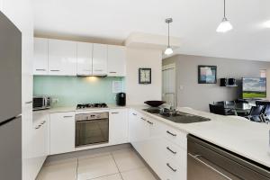 a kitchen with white cabinets and a stove top oven at Keith's Sister, 1 of the 4 most popular units on Bribie in Bongaree