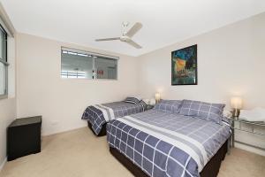 a bedroom with two beds and a ceiling fan at Keith's Sister, 1 of the 4 most popular units on Bribie in Bongaree