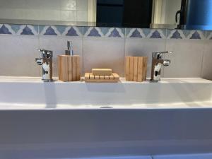 ein Badezimmerwaschbecken mit zwei Wasserhähnen und Holzklötzen darauf in der Unterkunft AGAVE Suite in San Ligorio + 16 Fotos