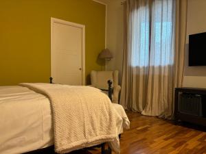 ein Schlafzimmer mit einem Bett und einem Stuhl und einem Fernseher in der Unterkunft AGAVE Suite in San Ligorio