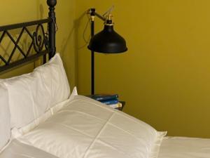 ein Schlafzimmer mit einem weißen Bett mit einer Lampe und Büchern in der Unterkunft AGAVE Suite in San Ligorio