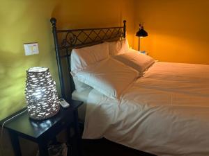 ein Schlafzimmer mit einem Bett und einer Lampe auf einem Tisch in der Unterkunft AGAVE Suite in San Ligorio