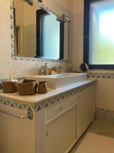 ein Badezimmer mit Waschbecken und Spiegel in der Unterkunft AGAVE Suite in San Ligorio