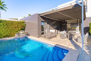 a swimming pool in front of a house at Villa La Finca Golf in Algorfa