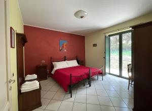 a red bedroom with a bed with a red blanket at Pietrabianca Country House in Manocalzati