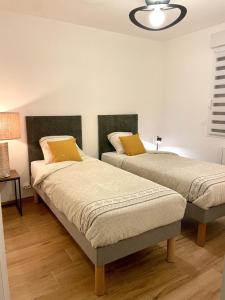 two beds with yellow pillows in a room at Loguel an placen in Saint-Laurent