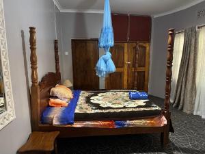 a bedroom with a bed with a wooden frame at EKO Holiday Homes, Lake Chala in Taveta