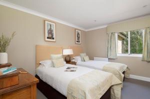 a bedroom with two beds and a desk and a window at Landal Hexham Lodges in Slaley
