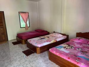a room with three beds and a window at เฮินไตเกสเฮาส์ in Ban Nong Pa Ko