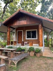 a small house with a bench and a table at เฮินไตเกสเฮาส์ in Ban Nong Pa Ko