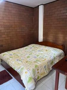 a bed in a room with a brick wall at เฮินไตเกสเฮาส์ in Ban Nong Pa Ko