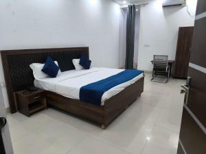 a bedroom with a large bed with blue pillows at Hotel O Sector 110 Noida Formerly Luv Kush Tower Bhangel in Noida