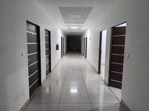 an empty hallway with doors and a hallwayngth at Hotel O Sector 110 Noida Formerly Luv Kush Tower Bhangel in Noida