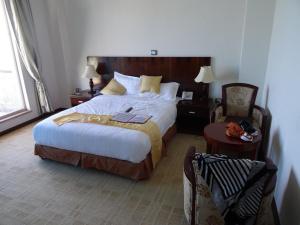 una camera da letto con un letto grande e una sedia di Sarem International Hotel & Spa ad Addis Abeba Altre 13 foto