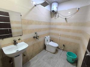 a bathroom with a sink and a toilet and a mirror at Hotel O Sector 110 Noida Formerly Luv Kush Tower Bhangel in Noida
