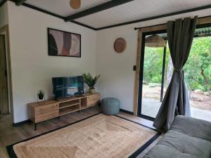 a living room with a tv and a window at Luxury Unit with Mountain Views & Splash Pool in Oudtshoorn
