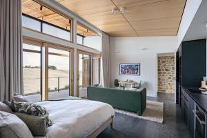 a bedroom with a bed and a large window at Studio on Forktree – Modern Coastal Retreat in Carrickalinga