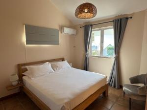 a small bedroom with a bed and a window at Lakaz Mapou - Magnifiques Appartements rénovés de 3 chambres et 2 salles de bains in Rivière Noire +29 photos