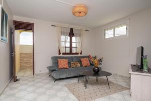 Maison Vue du Ciel - Proche de l'aéroport في ليه أبيم: غرفة معيشة بها أريكة وطاولة