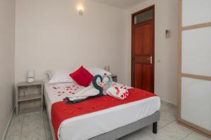 Maison Vue du Ciel - Proche de l'aéroport في ليه أبيم: غرفة نوم مع سرير مع مناشف الحيوانات عليه