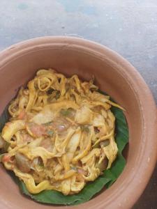 a brown bowl of food with noodles in it at Villa diamond nest in Unawatuna