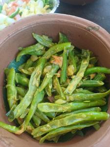 a bowl filled with green beans with a salad at Villa diamond nest in Unawatuna