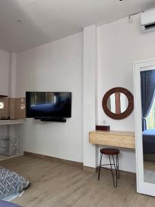 ein Schlafzimmer mit einem Fernseher an der Wand und einem Stuhl in der Unterkunft The Inside House Medewi in Airsatang