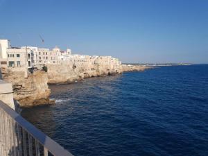 a large body of water with buildings on the shore at dimora princ di napoli 14 in Polignano a Mare