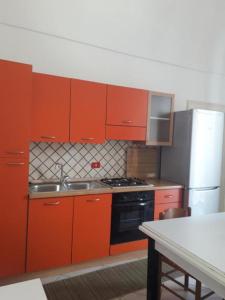 a kitchen with red cabinets and a stove and refrigerator at dimora princ di napoli 14 in Polignano a Mare