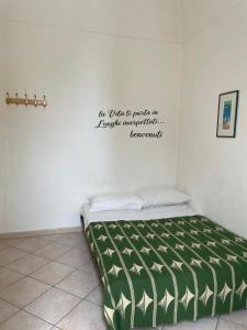 a bed in a room with a sign on the wall at dimora princ di napoli 14 in Polignano a Mare +4 photos