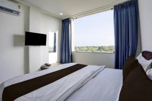 um quarto com uma cama e uma janela grande em Collection O Hingna City Court Nagpur Formerly Hotel Dream Inn em Khāpri