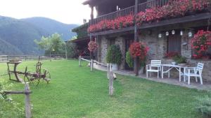 a house with a table and chairs in a yard at Cal Sadurní in Planoles