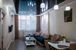 a living room with a blue couch and a table at Luxury 2 Bedrooms Apartment with 2 bathrooms & Batumi center in Batumi