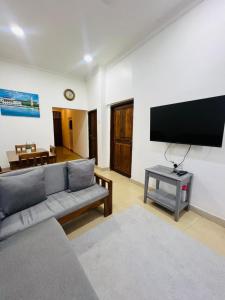 a living room with a couch and a flat screen tv at Vuga Town House in Zanzibar City +13 photos