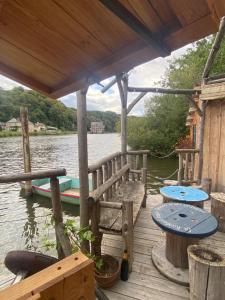 un molo con tavoli e una barca sull'acqua di Chalet sur l'eau a Brissarthe