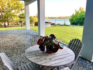 a wooden table with a vase of flowers on it at Mangawhai Estuary Escape in Mangawhai