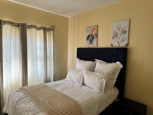 ein Bett mit weißen Laken und Kissen in einem Schlafzimmer in der Unterkunft Hatfield Staylax Manor 4 in Harare