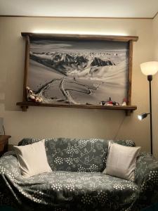 a couch in a living room with a painting on the wall at mountain summit sestriere in Sestriere