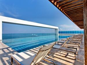 una piscina con tumbonas en un edificio en Las Americas Torre Del Mar, en Cartagena de Indias