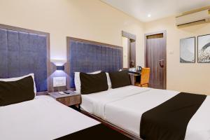 ein Hotelzimmer mit zwei Betten und einer Lampe in der Unterkunft Townhouse LBS Road BKC Formerly Royal Palace in Mumbai + 21 Fotos