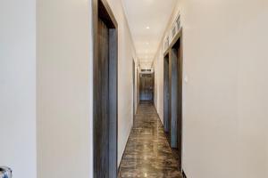 ein Flur mit weißen Wänden und ein langer Flur mit blauen Türen in der Unterkunft Townhouse LBS Road BKC Formerly Royal Palace in Mumbai