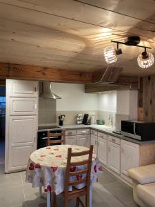 eine Küche mit Tisch und eine Küche mit Holzdecken in der Unterkunft Le repaire de l'horloger in Maîche