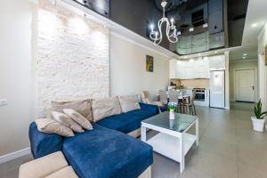 a living room with a blue couch and a table at Luxury 2 Bedrooms Apartment with 2 bathrooms & Batumi center in Batumi +70 photos