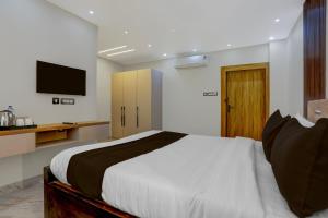 BāliantaSuper Townhouse Puri Bypass Crossway Formerly Hotel Pratee Heights的一间带大床和电视的卧室 更多24张照片