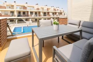 a table and chairs on a balcony with a pool at 3 bedroom, two-level, morden apartment in Orihuela Costa