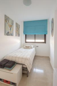 a bedroom with a bed and a blue window at 3 bedroom, two-level, morden apartment in Orihuela Costa +7 photos
