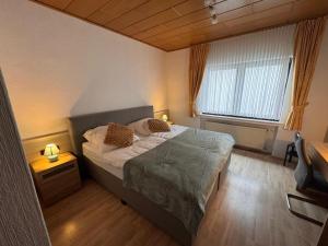 a bedroom with a bed and a large window at Hotel Restaurant Waldschlößchen in Neheim-Hüsten